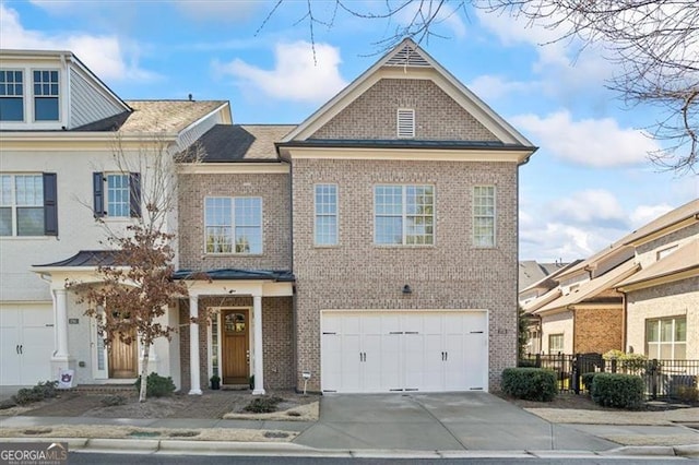 townhome / multi-family property featuring brick siding, concrete driveway, fence, and a garage