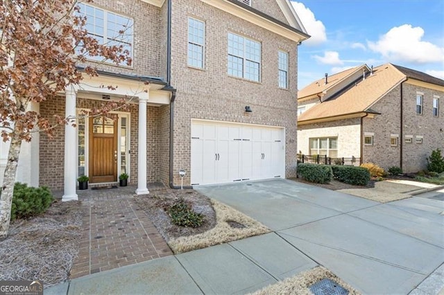 view of front of property featuring brick siding, concrete driveway, and an attached garage