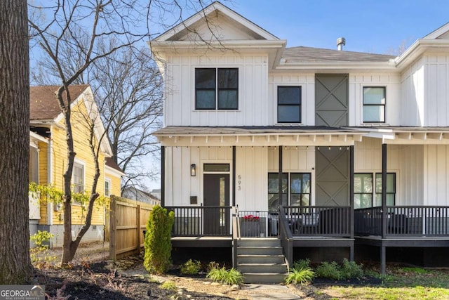 view of front of house with fence, covered porch, and board and batten siding