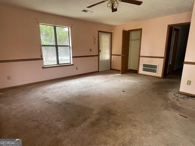 unfurnished bedroom with a textured ceiling, carpet flooring, visible vents, and baseboards