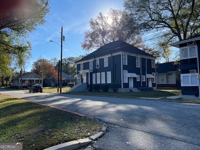 view of street featuring curbs, a residential view, sidewalks, and street lights