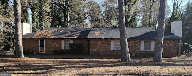 exterior space featuring a chimney and brick siding