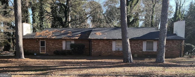 view of home's exterior with a chimney and brick siding