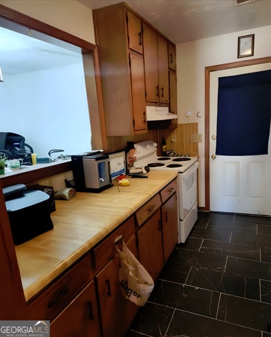 kitchen with light countertops, white electric range oven, under cabinet range hood, visible vents, and brown cabinets