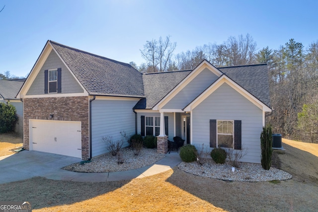 view of front of property with driveway, brick siding, a shingled roof, central AC, and covered porch