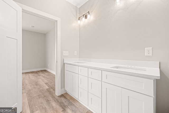 bathroom with a sink, baseboards, and wood finished floors