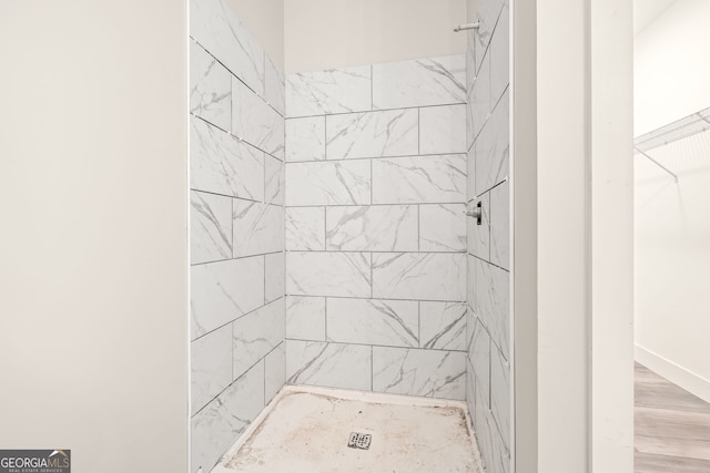 full bathroom featuring a shower stall and wood finished floors