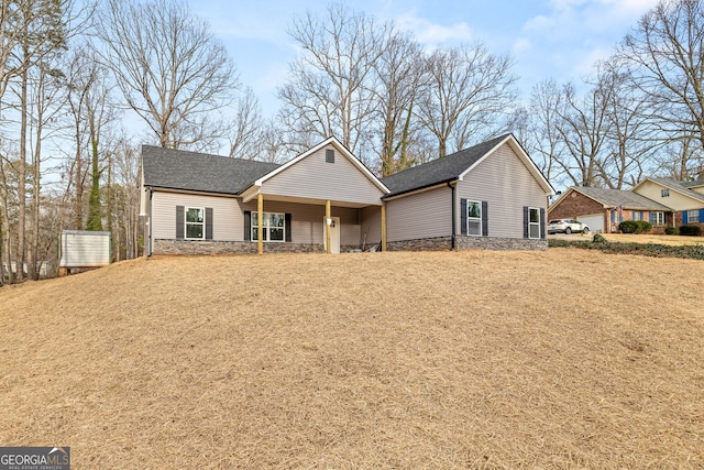 view of front of home featuring stone siding and a shingled roof