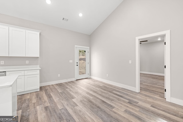 unfurnished dining area with high vaulted ceiling, light wood-style flooring, recessed lighting, visible vents, and baseboards