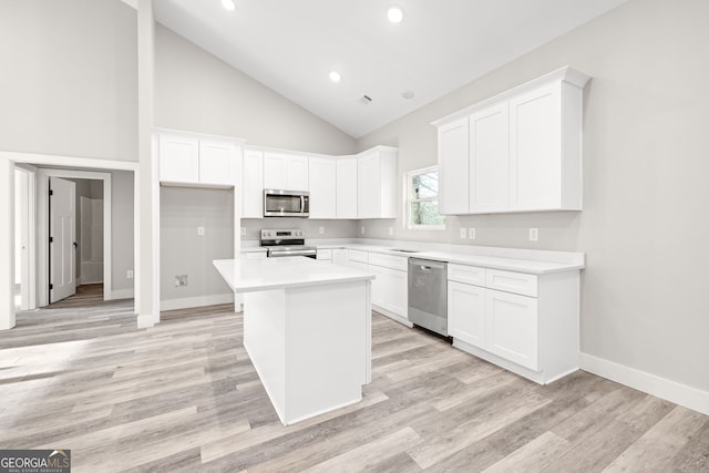 kitchen featuring light wood finished floors, appliances with stainless steel finishes, white cabinets, and a center island