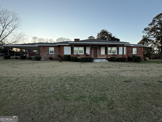 ranch-style house featuring a front lawn and a carport