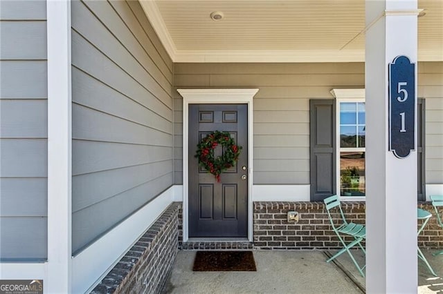 doorway to property with brick siding