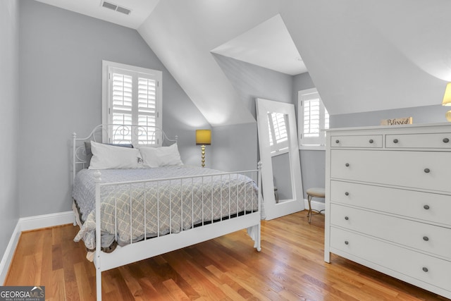 bedroom featuring lofted ceiling and light hardwood / wood-style floors