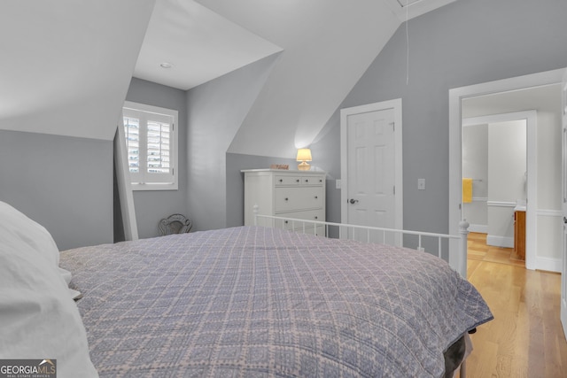 bedroom with light hardwood / wood-style flooring and lofted ceiling