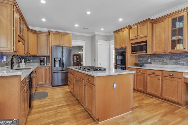 kitchen featuring a center island, light hardwood / wood-style floors, black appliances, ornamental molding, and light stone counters