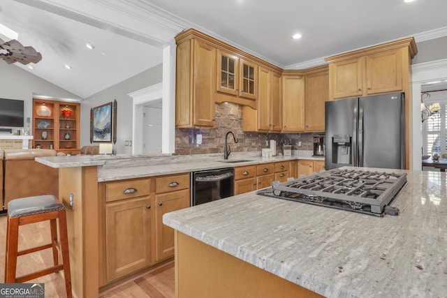 kitchen featuring light stone countertops, decorative backsplash, stainless steel appliances, and a kitchen bar