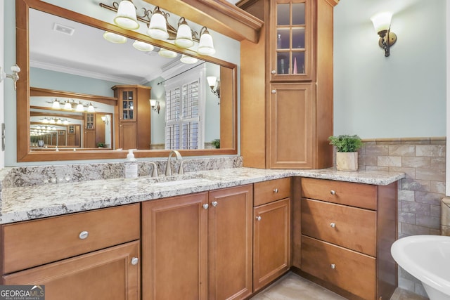 bathroom with ornamental molding, visible vents, a wainscoted wall, tile walls, and vanity