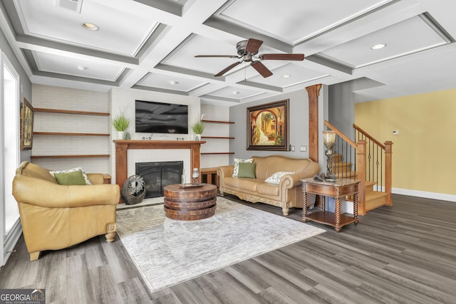 living room featuring stairs, baseboards, coffered ceiling, and wood finished floors