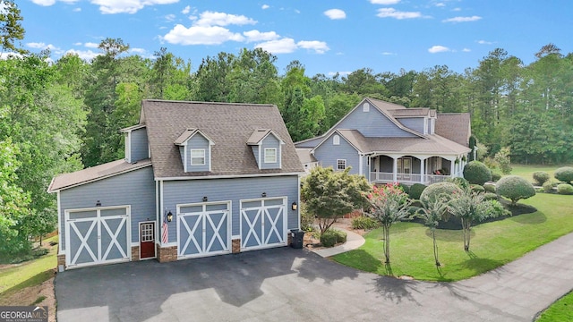 view of front of property with a shingled roof, aphalt driveway, and a front lawn