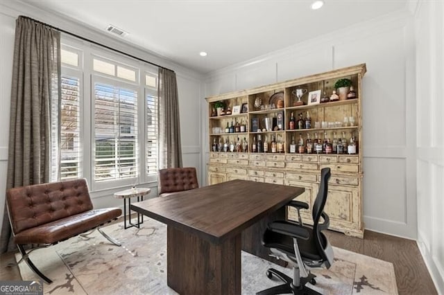 office space with ornamental molding, recessed lighting, dark wood finished floors, and a decorative wall