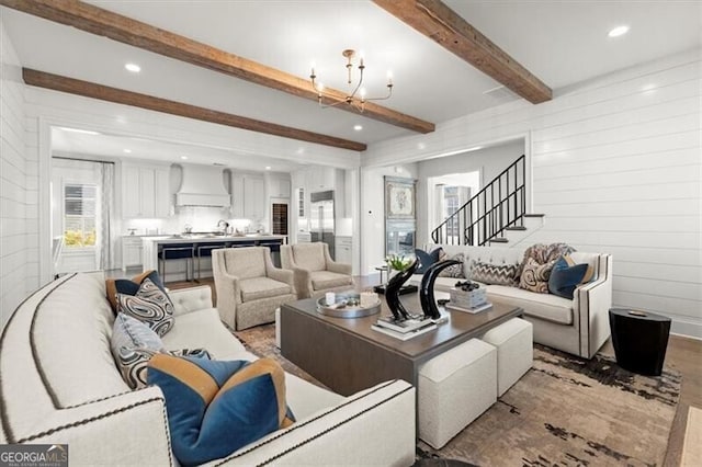 living room featuring beam ceiling, recessed lighting, an inviting chandelier, wood finished floors, and stairs