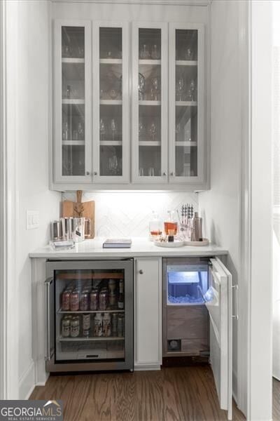 bar featuring wine cooler, dark wood finished floors, and a dry bar