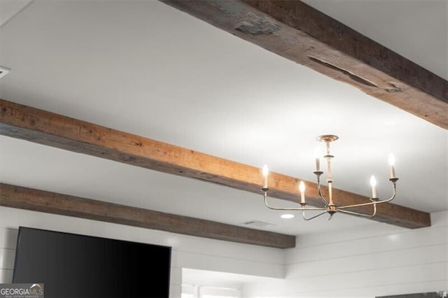 room details featuring a chandelier and beamed ceiling