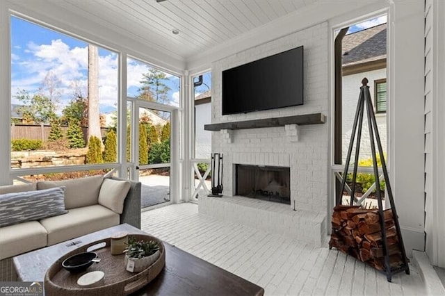 sunroom / solarium with a healthy amount of sunlight, a brick fireplace, and wooden ceiling