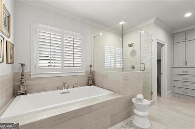 bathroom featuring ornamental molding, a shower stall, and a bath