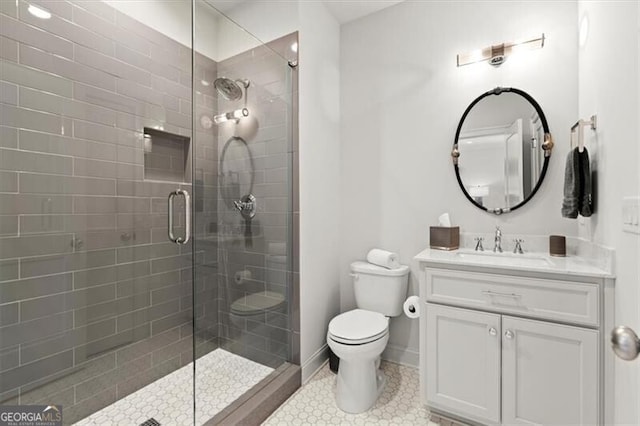 bathroom featuring tile patterned flooring, toilet, vanity, baseboards, and a stall shower