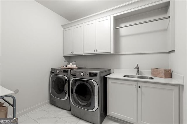 laundry area featuring a sink, baseboards, marble finish floor, cabinet space, and washing machine and clothes dryer