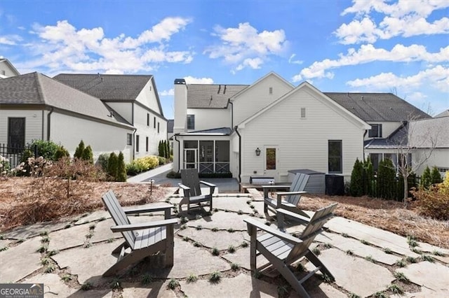 rear view of house featuring a sunroom and a patio area