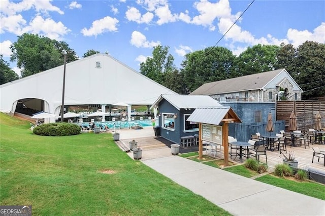 view of property's community featuring a lawn and fence