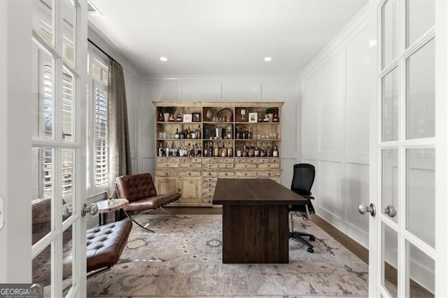 office with a decorative wall, crown molding, and french doors