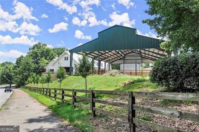 view of community with a covered structure, fence, and a detached carport