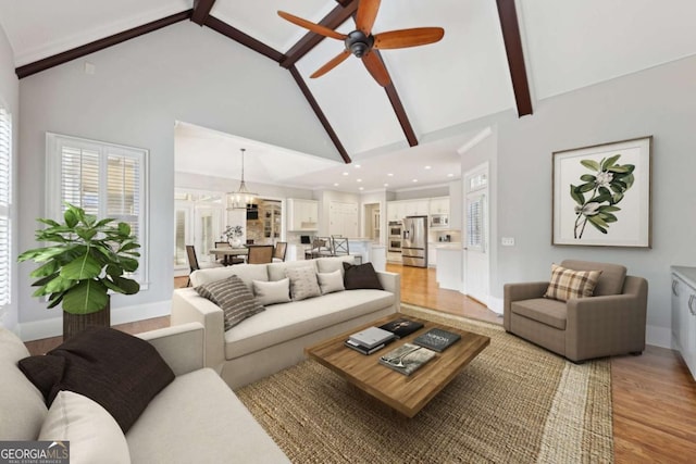 living area featuring beam ceiling, recessed lighting, light wood-style floors, high vaulted ceiling, and baseboards