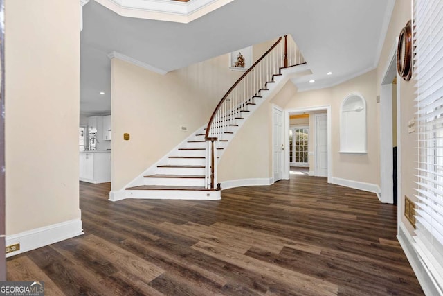 entryway featuring dark hardwood / wood-style flooring, crown molding, a wealth of natural light, and a skylight