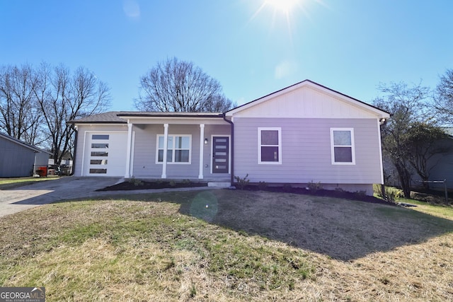 view of front of property with concrete driveway, board and batten siding, an attached garage, and a front yard