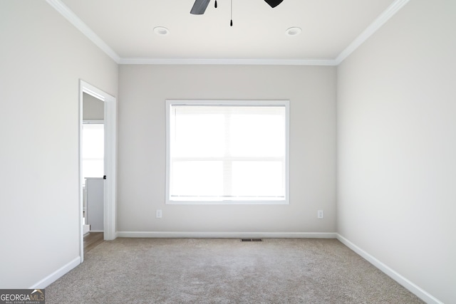 empty room featuring ornamental molding, baseboards, ceiling fan, and light colored carpet