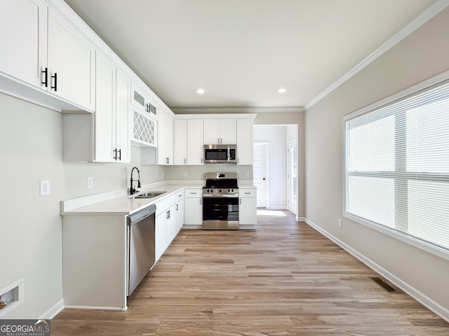 kitchen featuring appliances with stainless steel finishes, light countertops, visible vents, white cabinets, and a sink