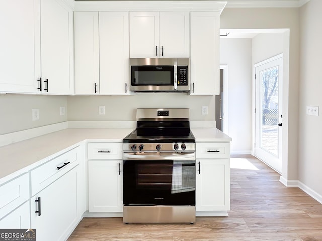 kitchen with light wood-type flooring, light countertops, white cabinets, and stainless steel appliances