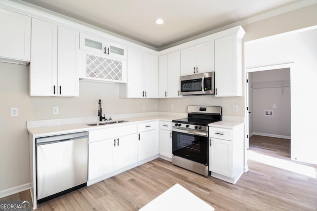 kitchen with light countertops, white cabinets, stainless steel appliances, and a sink