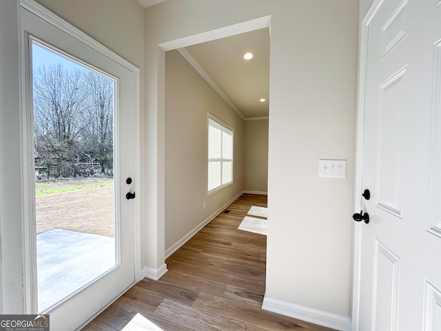 doorway featuring baseboards, recessed lighting, light wood finished floors, and ornamental molding