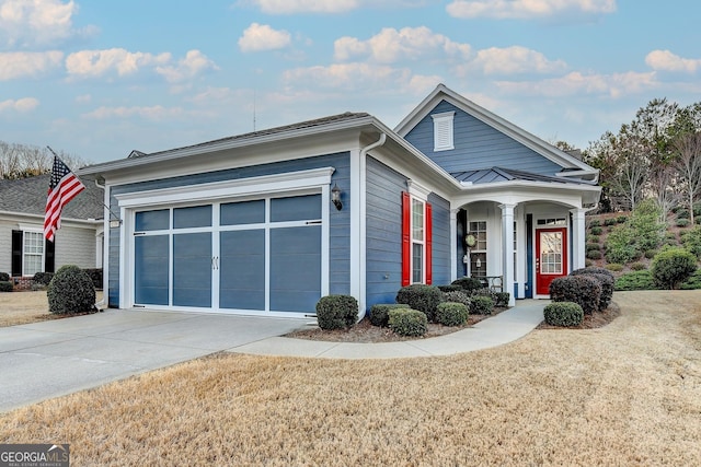 view of front facade featuring concrete driveway, an attached garage, a standing seam roof, metal roof, and a front lawn