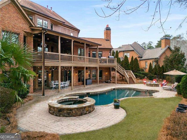 back of house with a fire pit, stairs, a pool with connected hot tub, and a patio