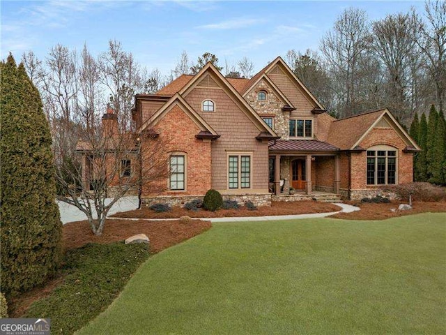 craftsman house with metal roof, a standing seam roof, and a front lawn