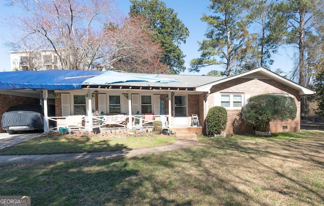 ranch-style house with brick siding, an attached carport, a porch, and a front lawn