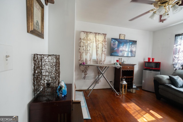 sitting room featuring ceiling fan, a healthy amount of sunlight, and dark wood finished floors