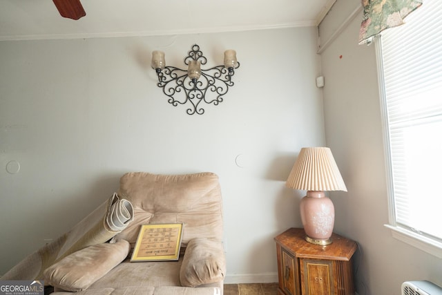 living area featuring baseboards and ornamental molding