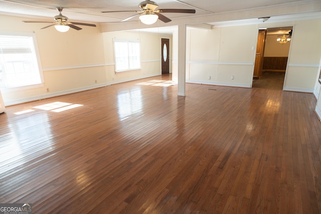 empty room featuring baseboards, a ceiling fan, and dark wood finished floors